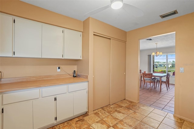 kitchen with ceiling fan with notable chandelier, visible vents, white cabinets, light countertops, and hanging light fixtures