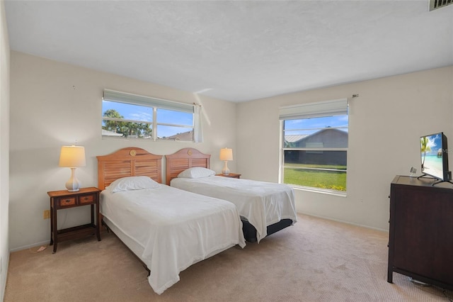 bedroom featuring light carpet, visible vents, and baseboards