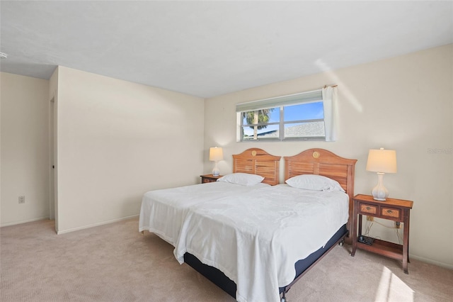 bedroom with baseboards and light colored carpet