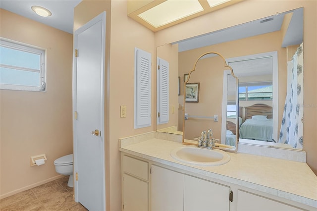 full bath with connected bathroom, toilet, vanity, baseboards, and tile patterned floors