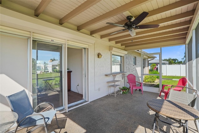 sunroom / solarium featuring beam ceiling, wooden ceiling, and ceiling fan