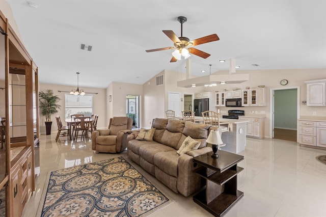 living room featuring lofted ceiling, visible vents, and ceiling fan with notable chandelier