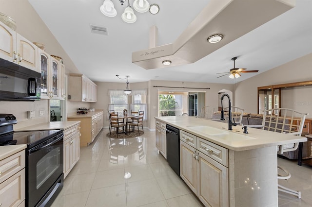 kitchen featuring black appliances, a breakfast bar, a sink, and light countertops