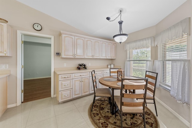 dining room with light tile patterned floors, lofted ceiling, and baseboards