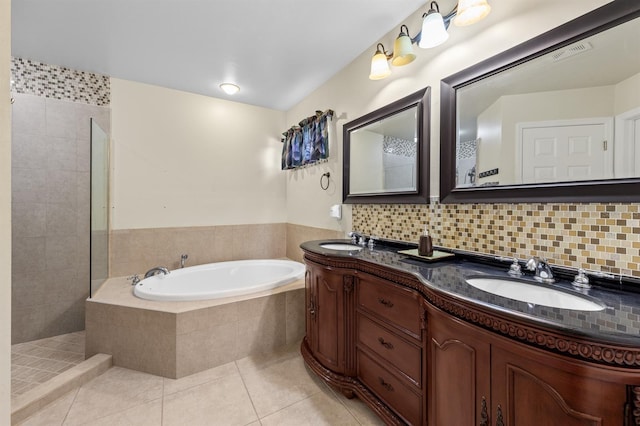 bathroom with a bath, decorative backsplash, a sink, and tile patterned floors