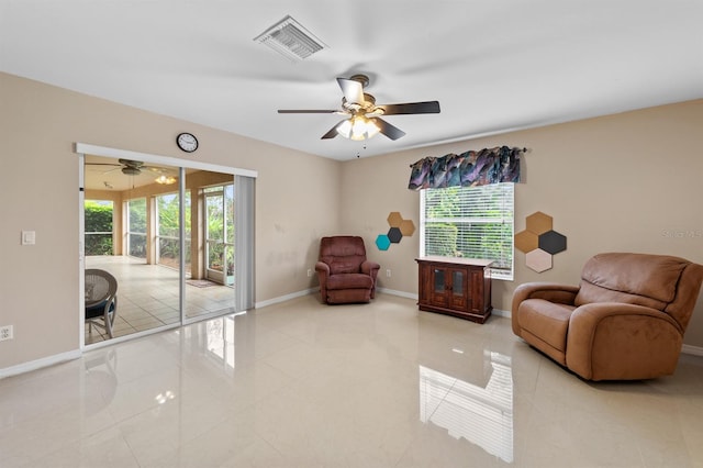 sitting room with a ceiling fan, visible vents, baseboards, and tile patterned floors