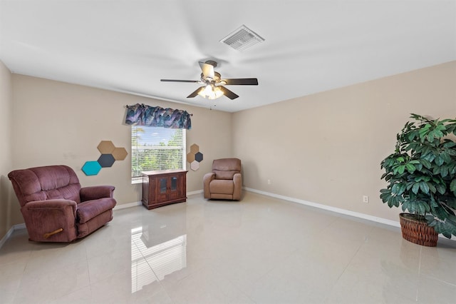 sitting room featuring visible vents, ceiling fan, baseboards, and light tile patterned floors