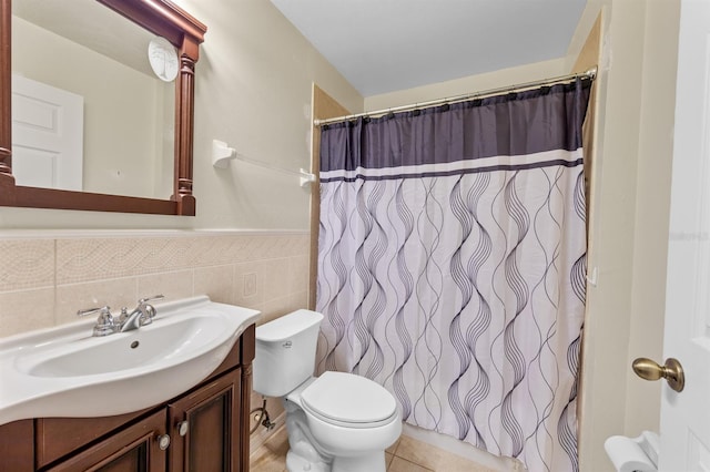 full bathroom featuring toilet, a wainscoted wall, tile patterned flooring, vanity, and tile walls