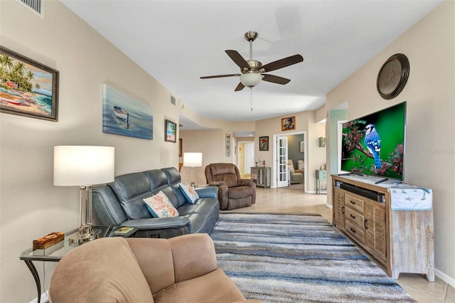 living room featuring visible vents, baseboards, and a ceiling fan