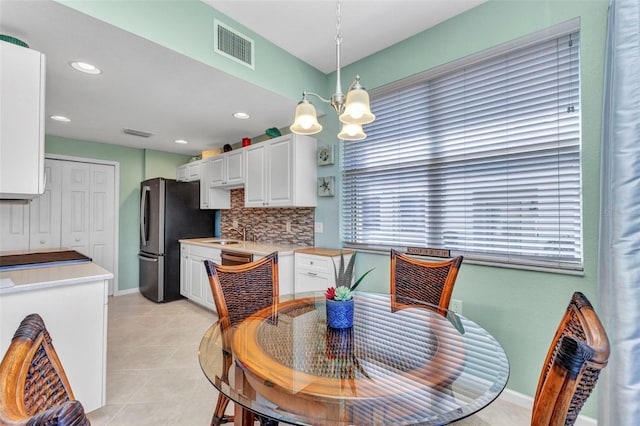 dining room featuring light tile patterned floors, baseboards, visible vents, recessed lighting, and a chandelier