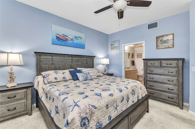 bedroom featuring baseboards, visible vents, ceiling fan, ensuite bathroom, and light carpet