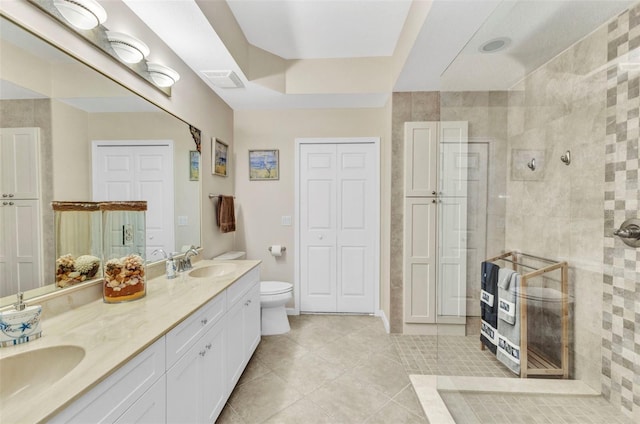 full bathroom with a sink, a closet, tiled shower, and visible vents