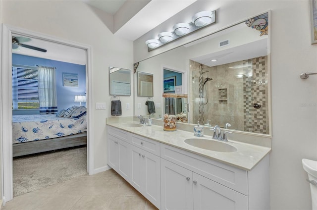 ensuite bathroom with a sink, visible vents, connected bathroom, and a tile shower