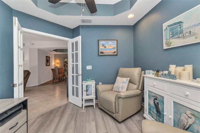 living area featuring visible vents, french doors, light wood-style floors, baseboards, and ceiling fan