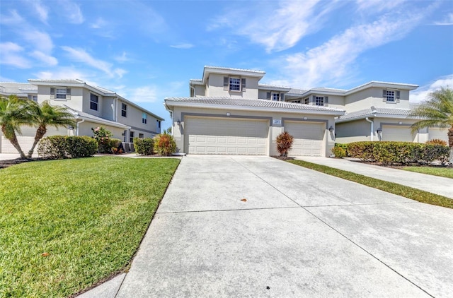 view of front of house featuring stucco siding, driveway, a front yard, an attached garage, and a tiled roof