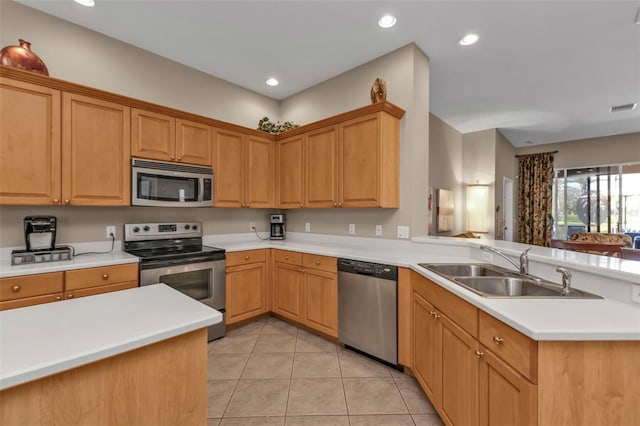 kitchen with visible vents, light countertops, appliances with stainless steel finishes, a peninsula, and a sink