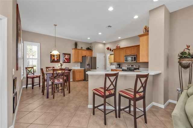 kitchen featuring recessed lighting, stainless steel appliances, a peninsula, and light countertops