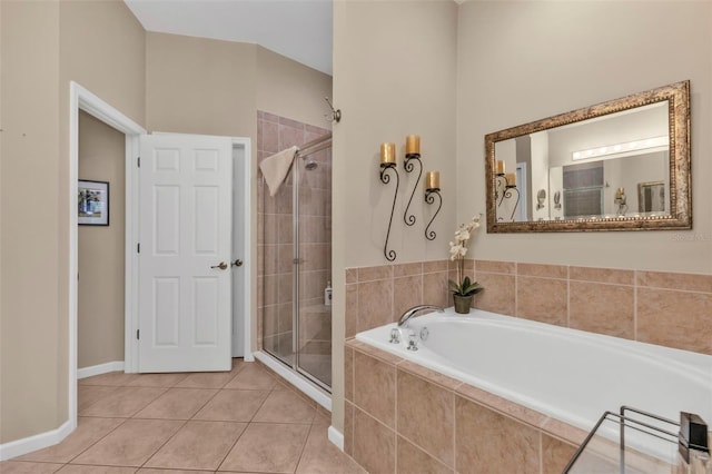 full bath featuring tile patterned flooring, a garden tub, baseboards, and a stall shower