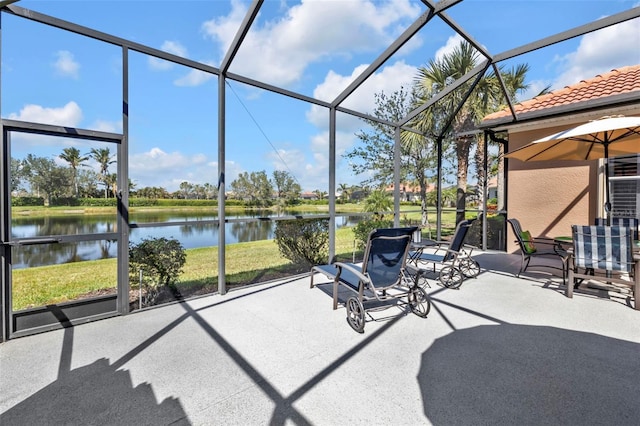 view of patio with glass enclosure and a water view