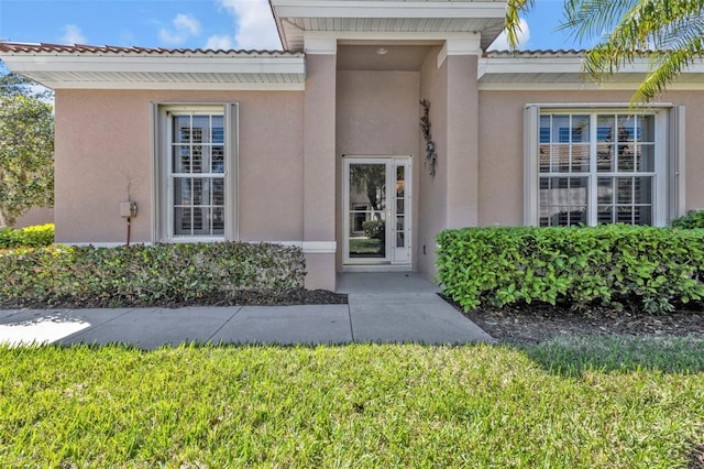 doorway to property featuring stucco siding