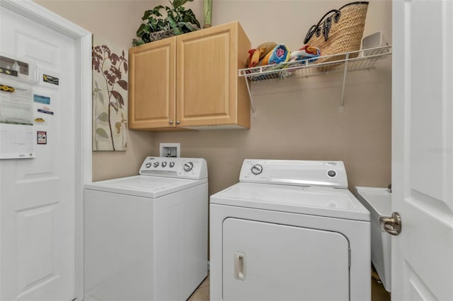 clothes washing area with washing machine and clothes dryer and cabinet space