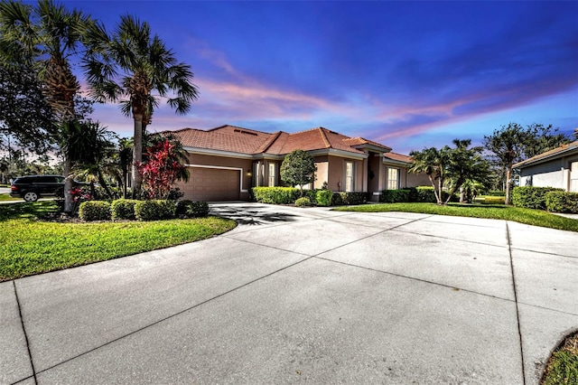 mediterranean / spanish home with a tiled roof, stucco siding, driveway, and an attached garage