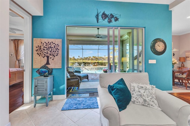 tiled living room with crown molding, baseboards, a sunroom, and ceiling fan