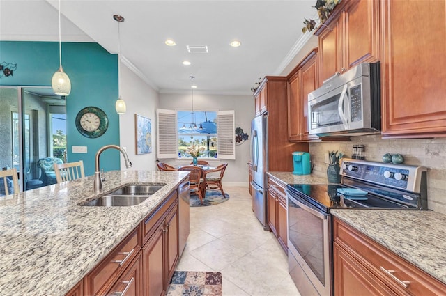 kitchen with a sink, appliances with stainless steel finishes, brown cabinetry, crown molding, and decorative backsplash