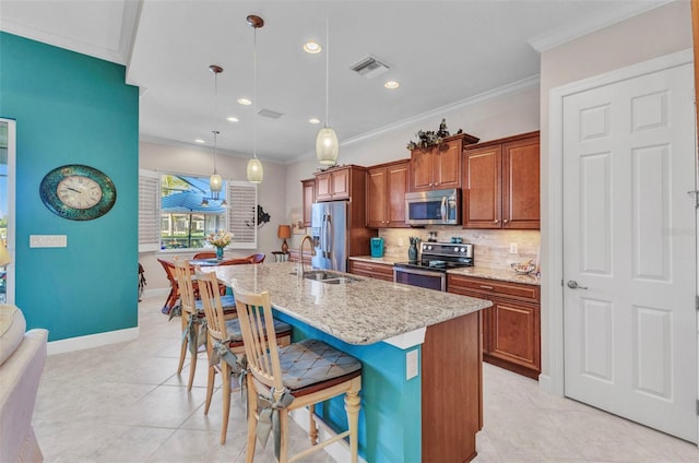 kitchen featuring a breakfast bar area, visible vents, a kitchen island with sink, a sink, and appliances with stainless steel finishes