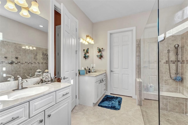 full bath with tile patterned floors, two vanities, a walk in shower, and a sink