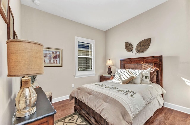 bedroom with baseboards and wood finished floors