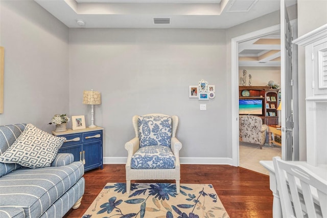 living area with dark wood-style floors, visible vents, and baseboards