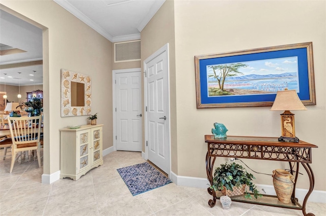 entrance foyer with tile patterned floors, visible vents, baseboards, and ornamental molding