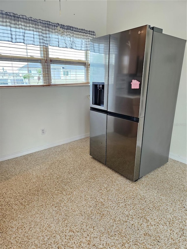 kitchen with baseboards, stainless steel fridge with ice dispenser, and speckled floor