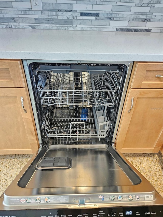 details featuring dishwashing machine and light brown cabinetry