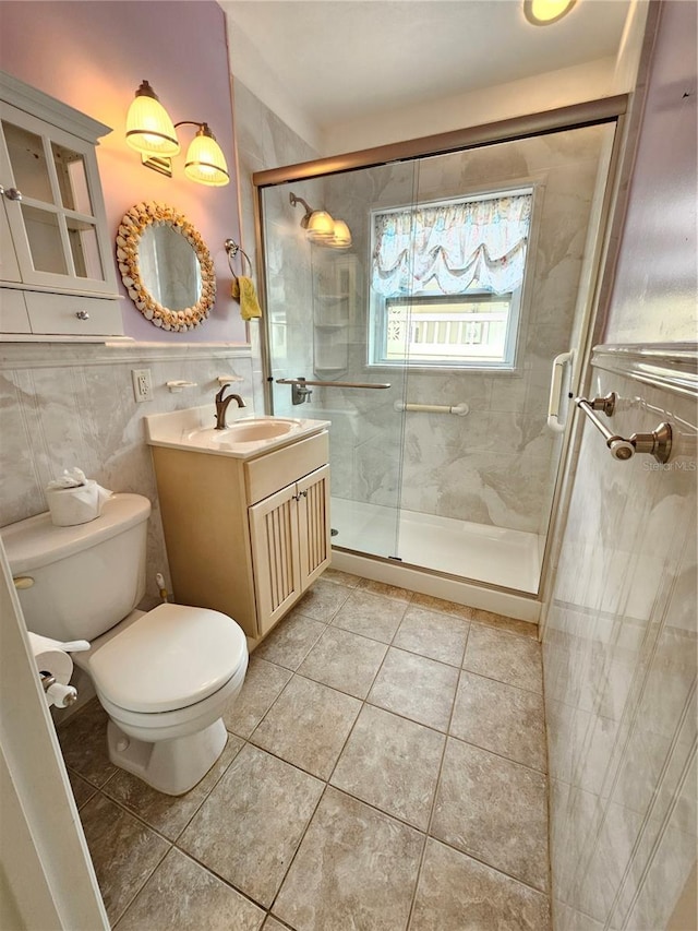 bathroom featuring tile walls, toilet, a shower stall, vanity, and tile patterned flooring