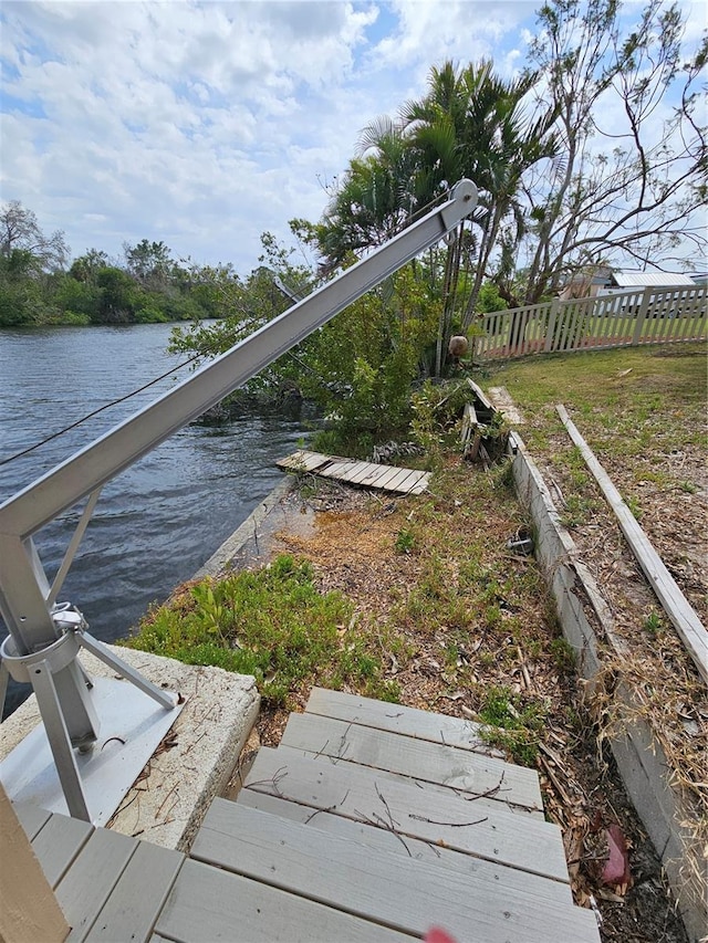 dock area with a water view and fence