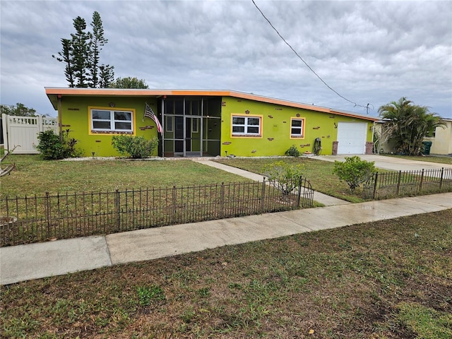 view of front facade with a fenced front yard, stucco siding, a garage, driveway, and a front lawn