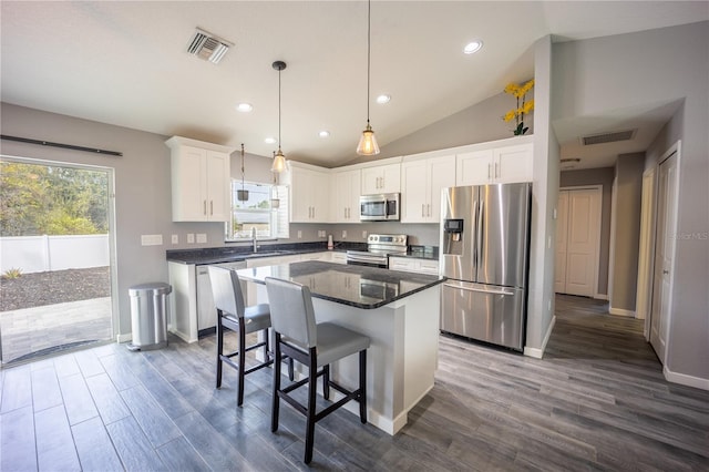 kitchen featuring stainless steel appliances, visible vents, dark wood-type flooring, white cabinets, and a sink