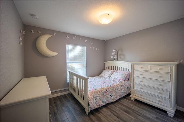 bedroom with dark wood-style floors and baseboards