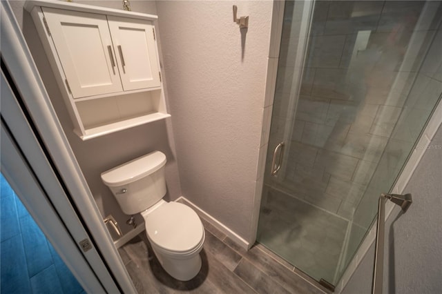 bathroom with baseboards, a textured wall, toilet, wood tiled floor, and a shower stall