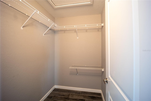 walk in closet featuring attic access and wood tiled floor