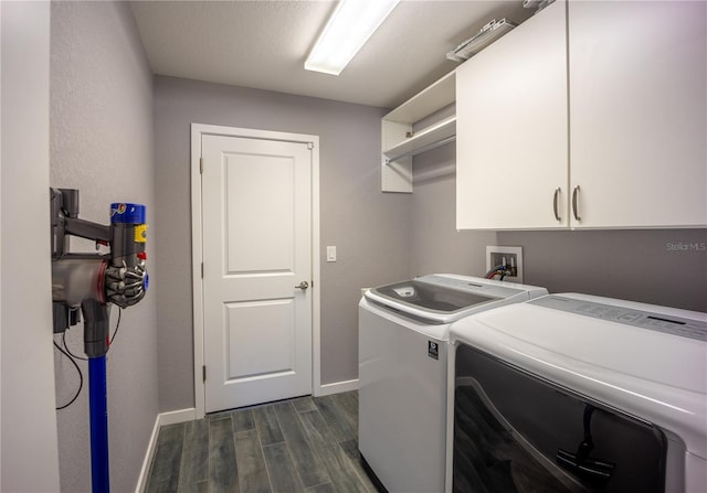 laundry area featuring cabinet space, baseboards, dark wood-style floors, and washing machine and clothes dryer