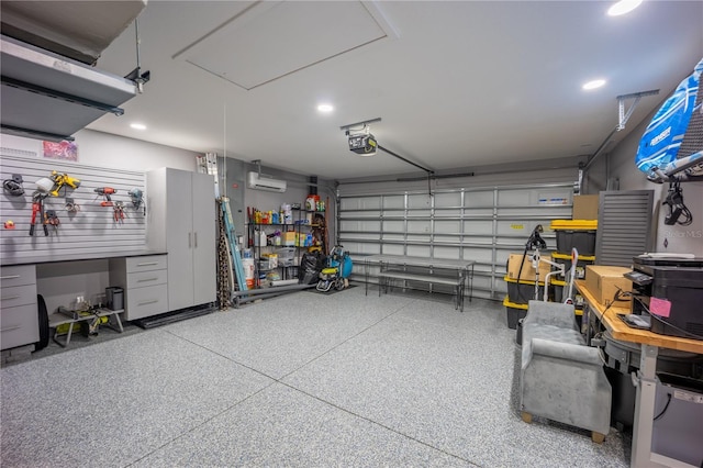 garage with a workshop area, a wall mounted AC, recessed lighting, and a garage door opener