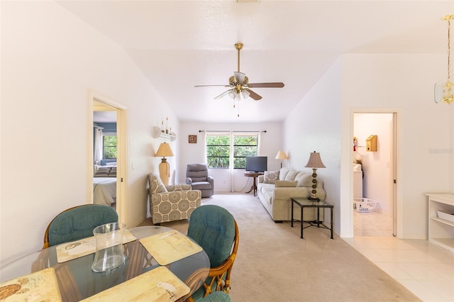 carpeted dining room with lofted ceiling, a ceiling fan, and tile patterned floors