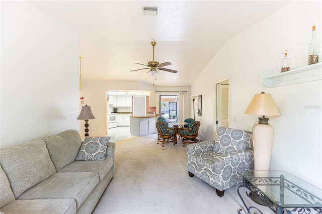 living room with a ceiling fan, light colored carpet, vaulted ceiling, and visible vents