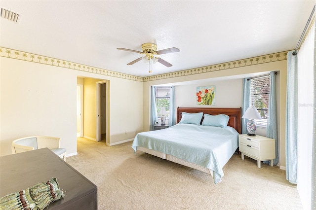 bedroom featuring light carpet, baseboards, visible vents, and a ceiling fan