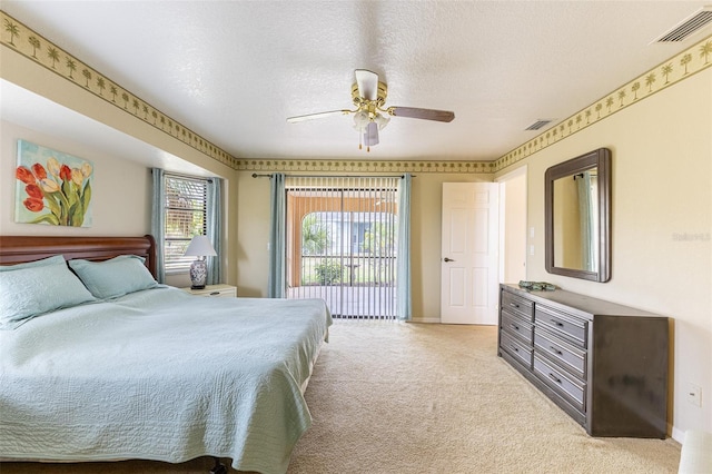 bedroom with a textured ceiling, light carpet, visible vents, baseboards, and a ceiling fan