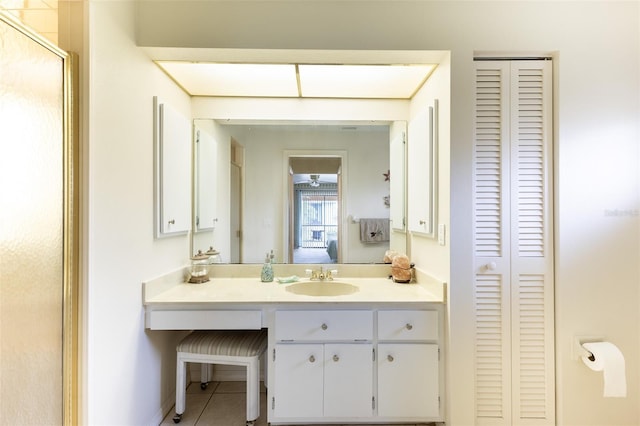 bathroom featuring a closet, a stall shower, vanity, baseboards, and tile patterned floors