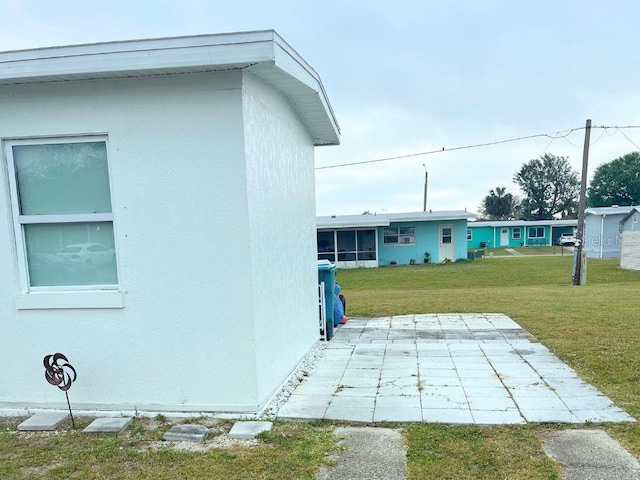 3116 Crestwood Dr, Port Charlotte, FL 33952 - view of side of property featuring a patio, a lawn, and stucco siding